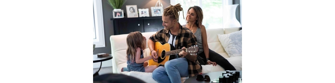 Dad and little girl playing the guitar while mom watches