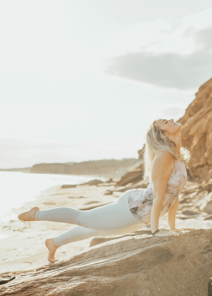blonde woman doing yoga at the beach